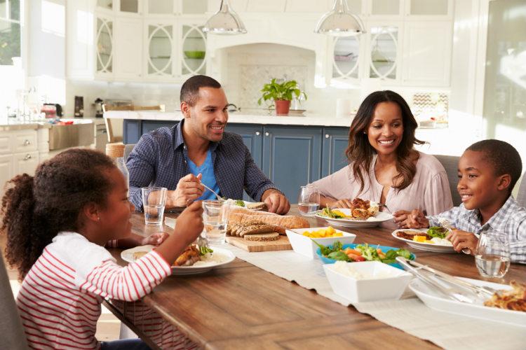 Família comendo juntos na mesa sorrindo