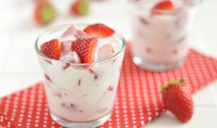 copo de iogurte natural branco com pedaços de morango