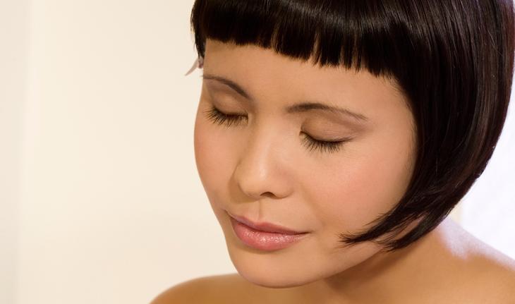 mulher japonesa com os olhos fechados, cabelo chanel e franja curta
