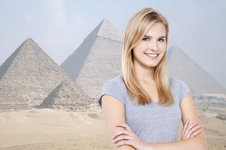 mulher loira com braços cruzados na frente das pirâmides egípcias