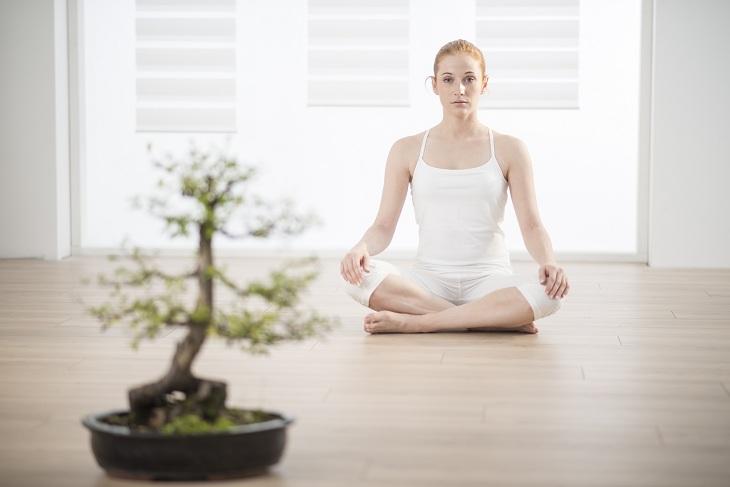 mulher sentada para fazer meditação