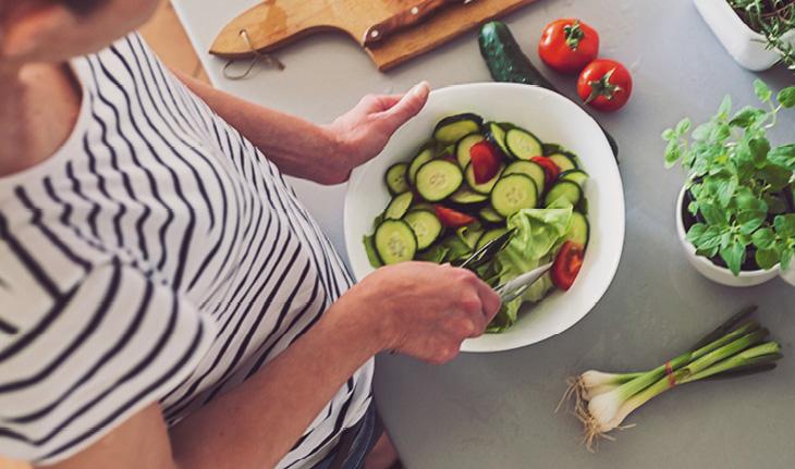 mulher preparando uma salada de pepino