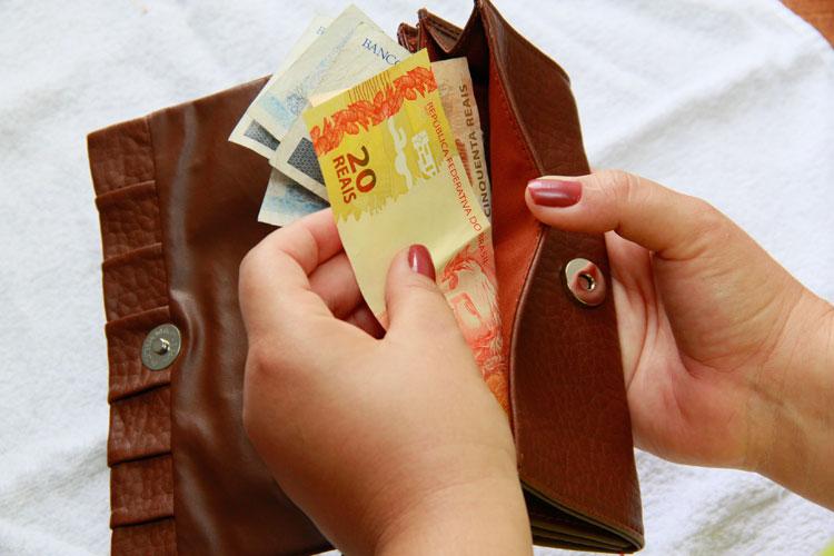 mão feminina tirando dinheiro da carteira, clientes inadimplentes