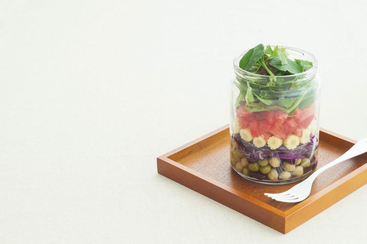 salada com alface, tomate e outros legumes dentro de um pote de vidro
