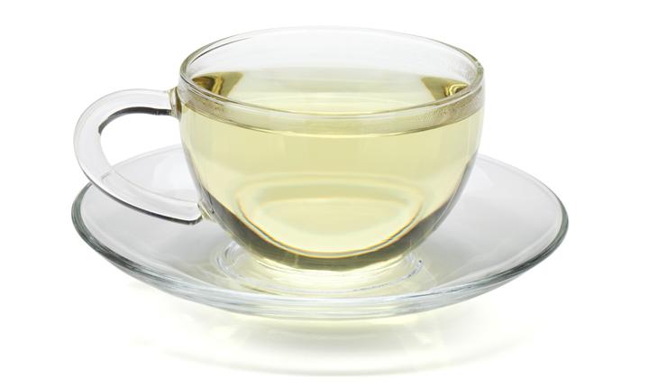 Xícara transparente de chá verde fundo branco