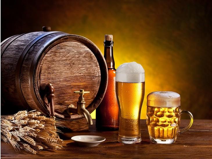 barril, copos e canecas de cerveja em cima de uma mesa de madeira
