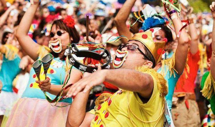 Pessoas fantasiadas sorrindo durante o bloco de carnaval