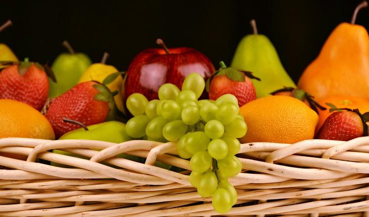imagem de uma cesta de frutas com uva verde, morango, pêra, maçã, laranja e maçã verde