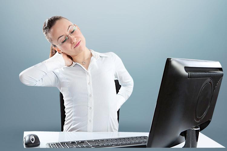 mulher sentada em frente ao computador, torta com com mão no pescoço e dor nas costas