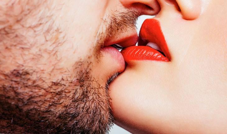 homem de barba beijando mulher de batom vermelho