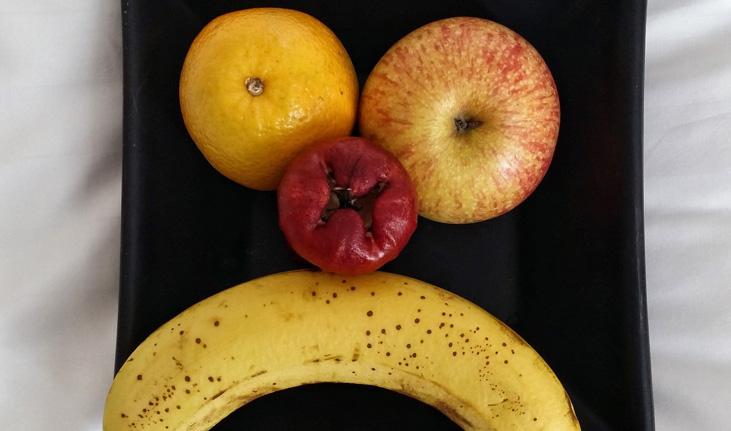 imagem de frutas em um prato formando um rosto triste