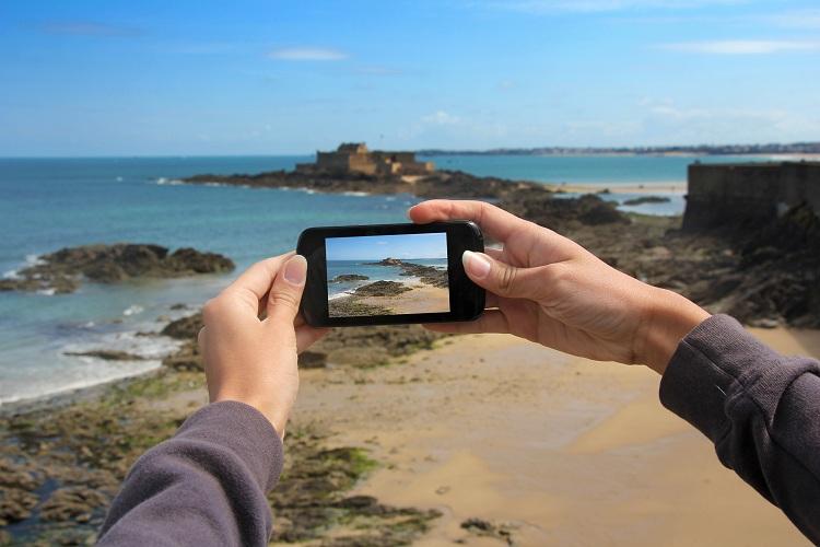 maos segurando celular smartphone android gravando vídeo praia