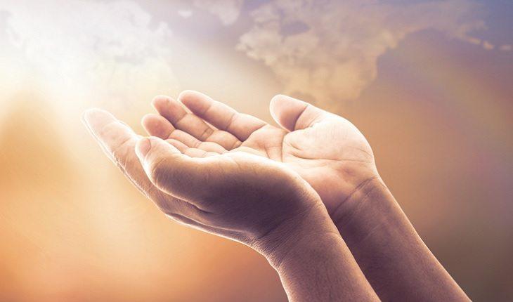A foto mostra uma mão aberta em direção aos céus, ilustrando uma das leis morais do espiritismo