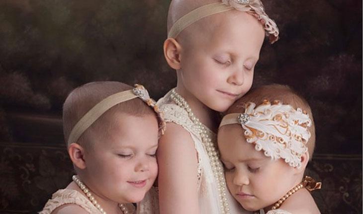 Três meninas com câncer infantil se abraçando