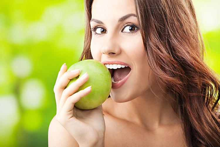 mulher comendo maçã verde