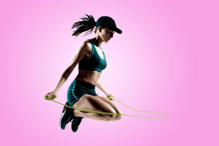 mulher com roupa de academia pulando corda, exercício em casa