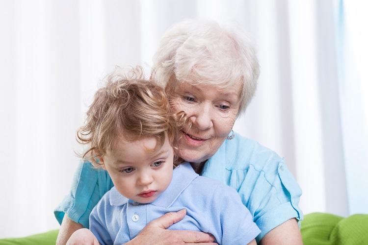 idosa de cabelos brancos segurando uma criança no colo, lidar com sogra