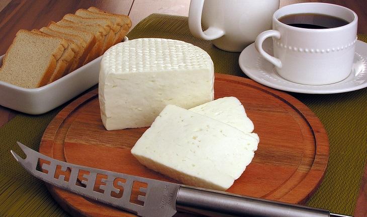 queijo branco em um tábua de madeira