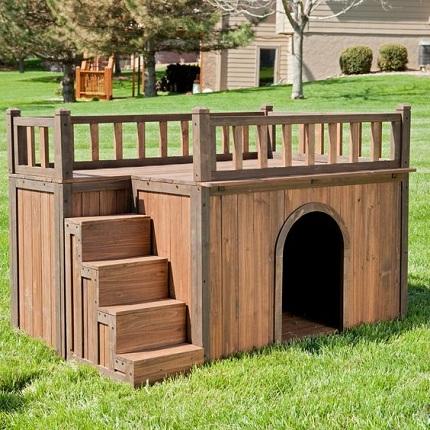 Casinha de cachorro feita em madeira com escadaria e terraço.