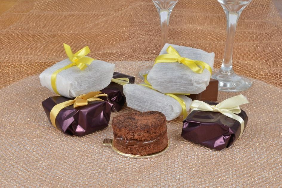 bem-casados de chocolate sobre um fundo de madeira, o primeiro está desembalado e o restante embalado, embalar bem-casados
