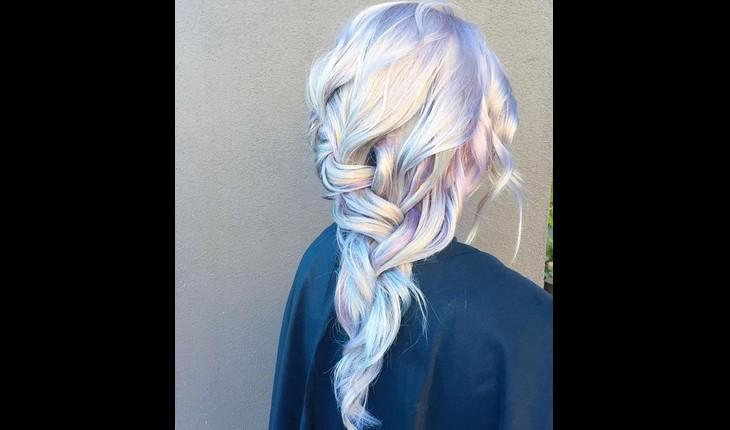 mulher mostra cabelo holográfico, com mechas super coloridas de diferentes cores
