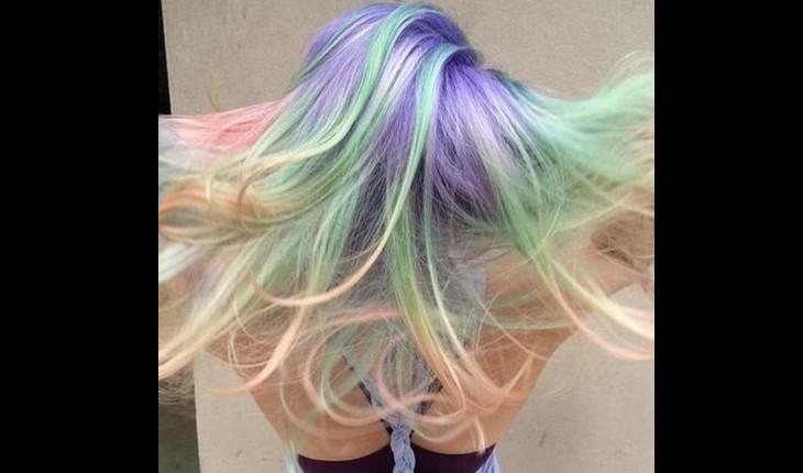 mulher mostra cabelo holográfico, com mechas super coloridas de diferentes cores