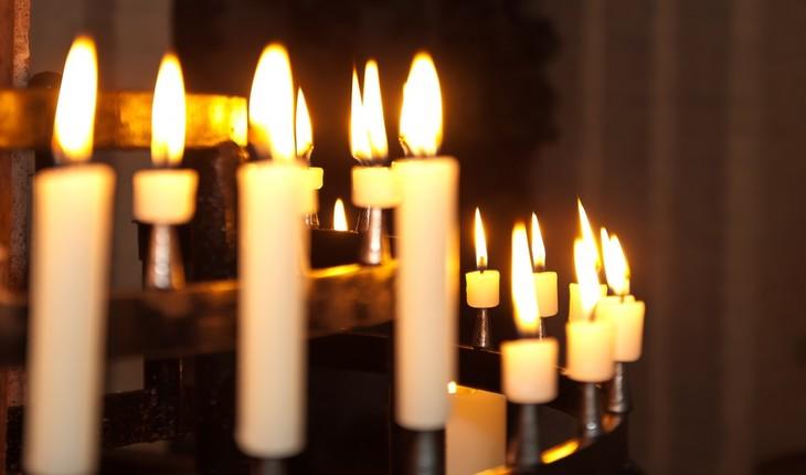 Imagem de algumas velas acesas em cima de um altar. Provérbios de Maio