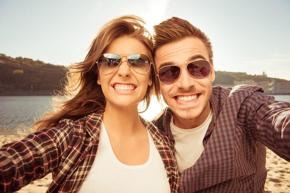 casal com óculos de sol sorrindo para a foto