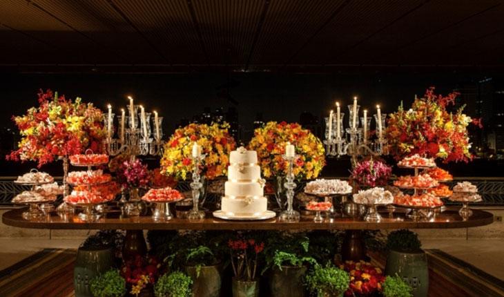Casamento rústico com flores debaixo da mesa do bolo