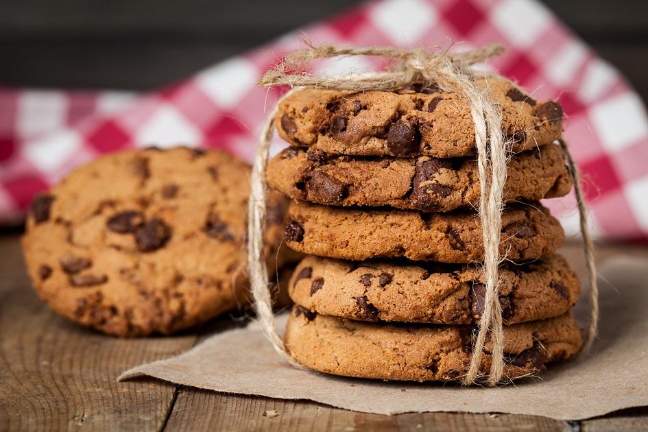 cookies tradicionais com gotas de chocolate ao leite, colocados um em cima do outro, amarrados com uma fita de sisal.