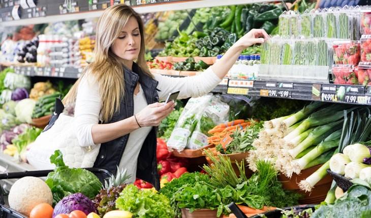 mulher no supermercado comprando legumes