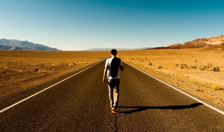 Pessoa andando sozinho em uma rodovia