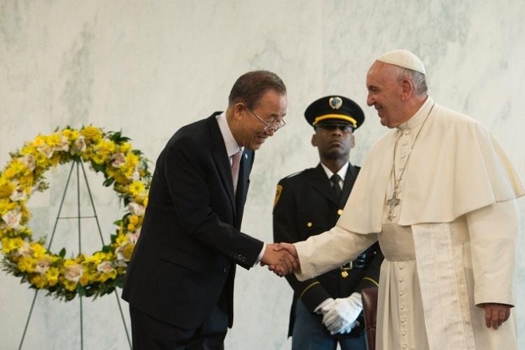 Na imagem, o Papa Francisco está dando as mãos a um senhor da ONU que faz uma reverencia. Mandando uma mensagem de paz