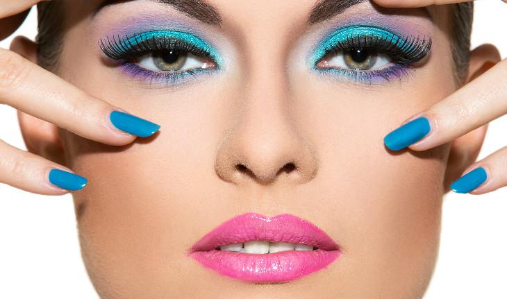 Mulher com maquiagem azuis nos olhos e batom rosa