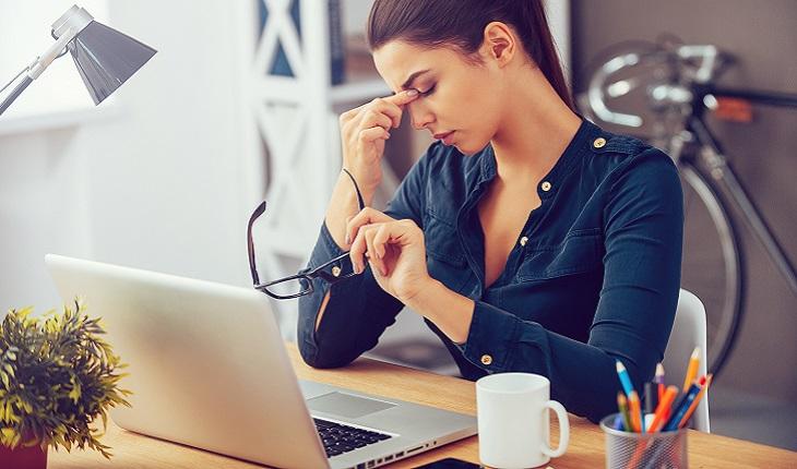 Mulher estressada no trabalho pensando em como ser mais concentrada