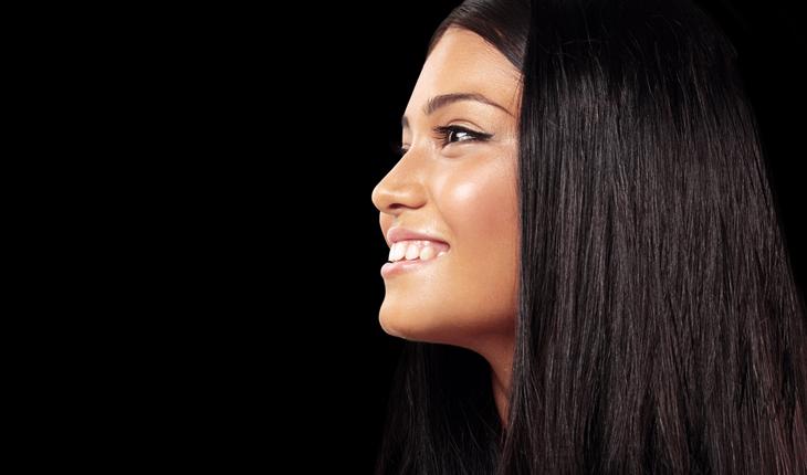 mulher negra com cabelo castanho escuro liso, sorrindo