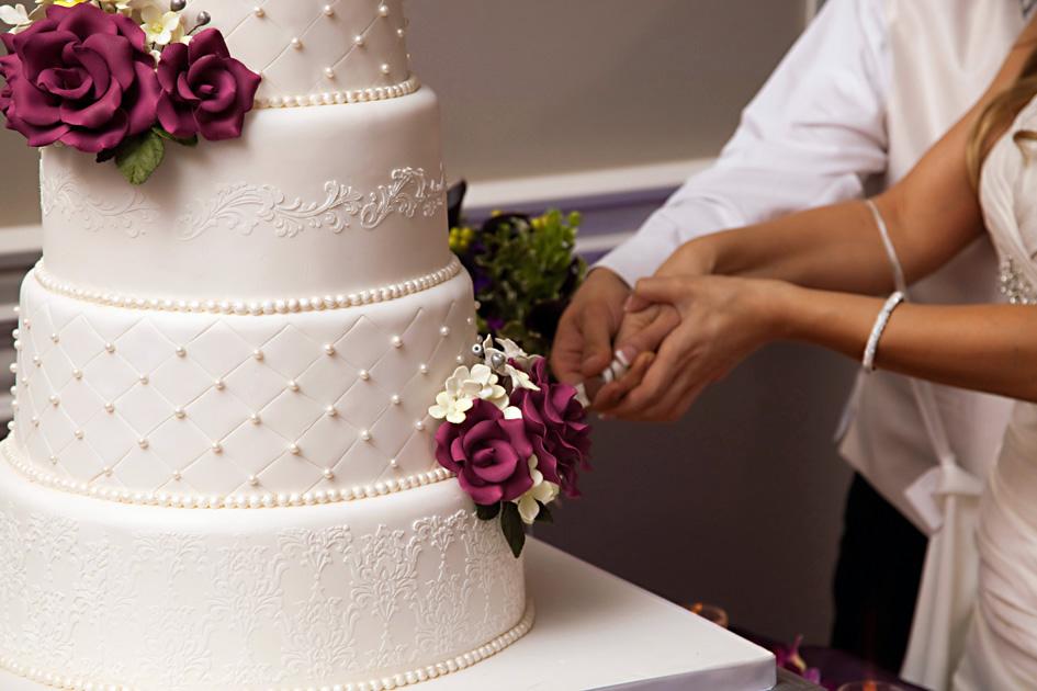 Casal de noivos cortando o bolo na festa de casamento