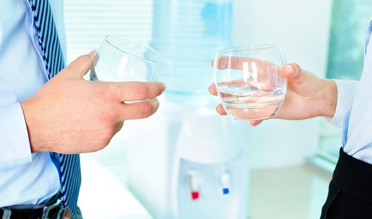 A foto mostra pessoas bebendo água em um escritório.