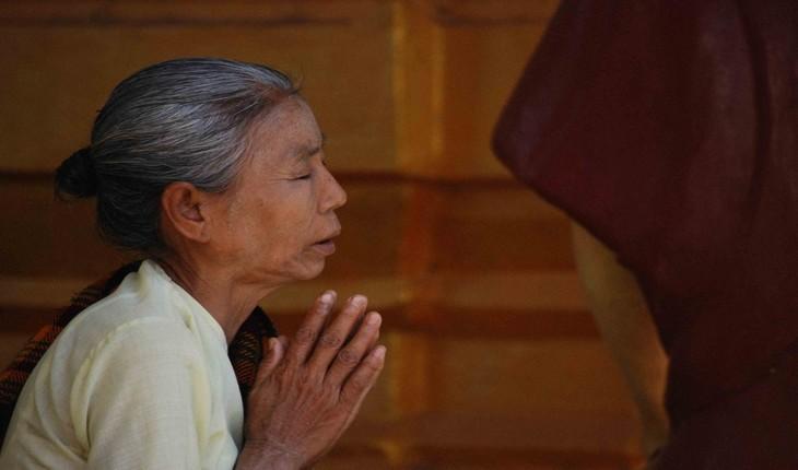 Foto de uma mulher com as mãos juntas e de olhos fechados orando. Provérbios de Maio