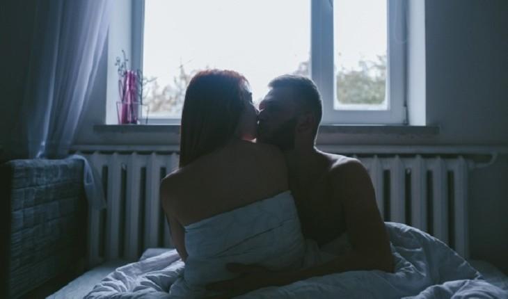 casal se beija em cama