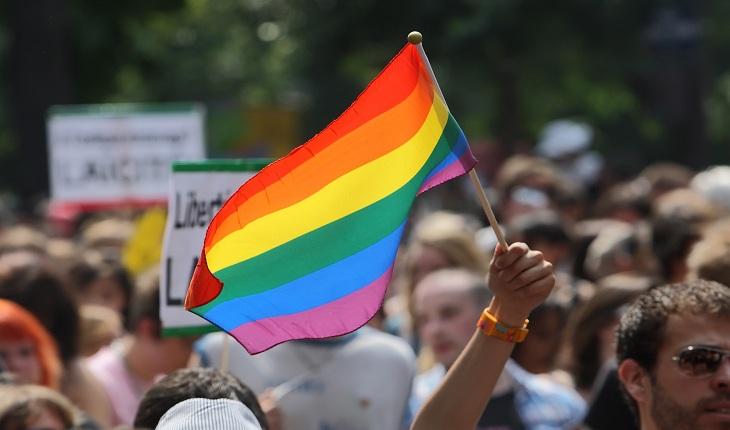 Mão levantada segurando bandeira LGBT