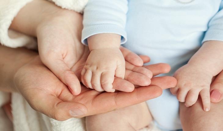 Mãos de um bebê sobre mãos femininas