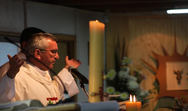 Imagem de um padre ministrando uma missa ao lado de algumas velas. Provérbios da semana