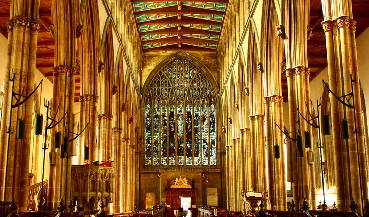 Imagem do inteiror de uma igreja antiga, de grande altura e com alguns vitrais em seu fundo, perto do autar do sacerdote. Provérbios da semana