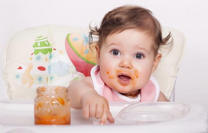 imagem de uma bebê com a boca suja de papinha