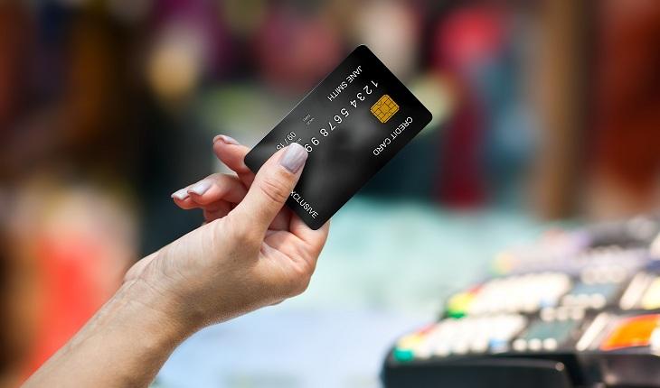mão feminina segurando cartão de crédito
