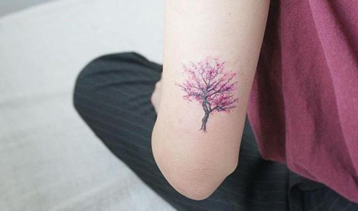 tatuagem de uma árvore cerejeira em preto e rosa
