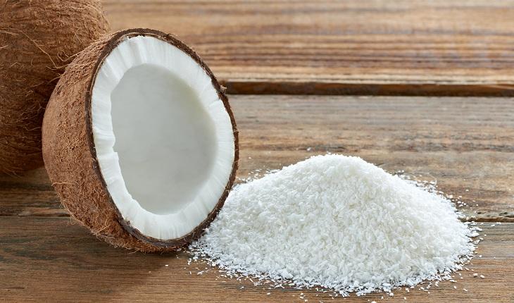 Coco seco, coco ralado sobre uma mesa de madeira