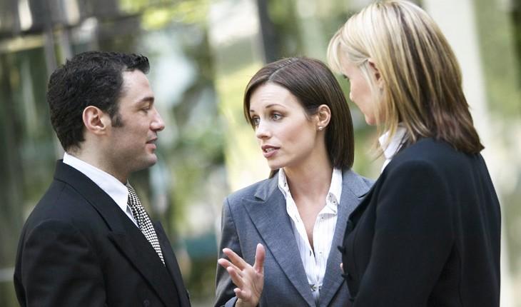 um homem e duas mulheres conversam na empresa