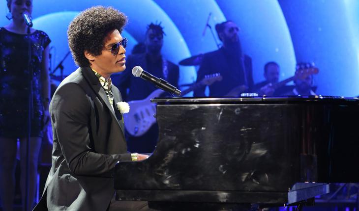 Enzo Romani caracterizado de Bruno Mars cantando e tocando piano no Show dos Famosos